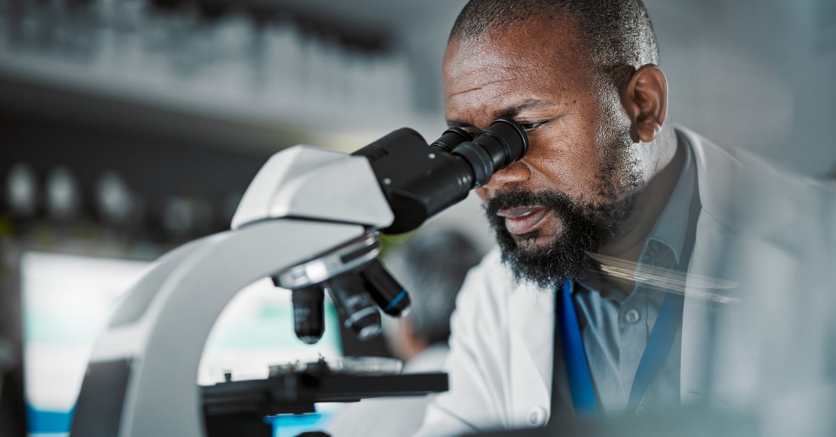 Pesquisador analisando amostra ao microscópio em laboratório